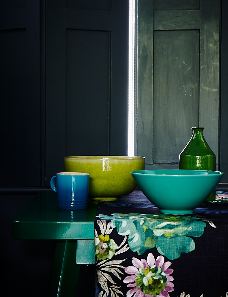 Interior still life styled by Mary Norden. Lime and aqua and green ceramics sit against an inky dark interior