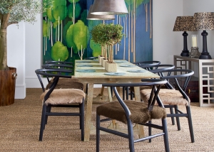 A striking rustic dining room with raw hide upholstered chairs and a raw wood dining table. Striking artwork in intense colours is great for the Autumn personality, according to colour psychology