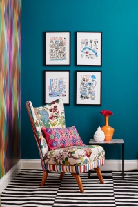 Arranging artwork by hanging pictures in classic symmetry creates a great focal point in an interior design room scheme. dark teal walls shows off the prints really well, as seen in the home of interior designer Sophie Robinson