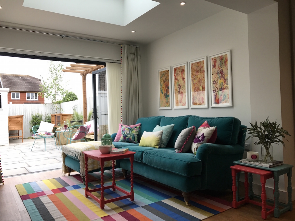 living room with teal velevet sofa and multi colour rug. Designed by interior designer Sophie Robinson for DIY SOS