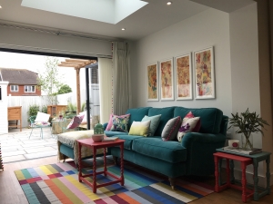 living room with teal velevet sofa and multi colour rug. Designed by interior designer Sophie Robinson for DIY SOS