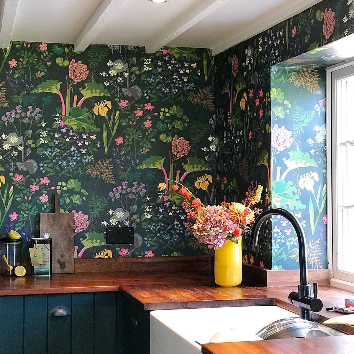 Interior Designer Sophie Robinson's kitchen Boras Tapeter Rabarber bright floral and rhubarb plants on dark green background wallpaper