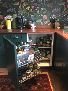 Interior Designer Sophie Robinson's kitchen Boras Tapeter Rabarber bright floral and rhubarb plants on dark green background wallpaper and corner unit