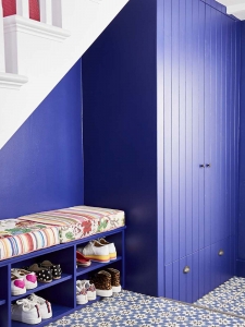 Interior designer Sophie Robinson has re-designed and renovated her hallway into and bright and welcoming space with under-stair show storage and cupboard all painted the same colour as the walls. #sophierobinson #shoestorage #hallway #renovation