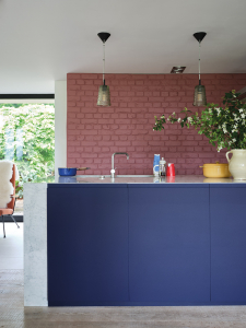 The strong pigment shows in this intense shade of blue on kitchen cabinets, it creates a welcoming feel against the bare red brick wall. Just one of the new paint collection by Farrow & Ball and The Natural History Museum. Interior designer Sophie Robinson takes a look through the whole collection here. #farrowandball #bluekitchen #barebrick #sophierobinson