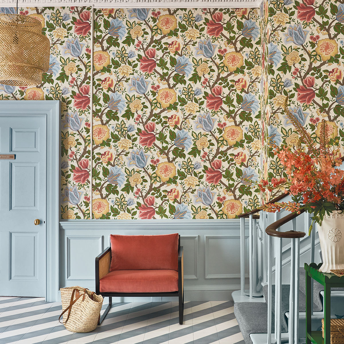 Interior designer and colour lover Sophie Robinson shares some top tips on how to use wallpaper. In this entrance hall a classic floral design is combined with pale blue panelling and a modern diagonal striped tiled floor. #entrancehall #sophierobinson #panelling