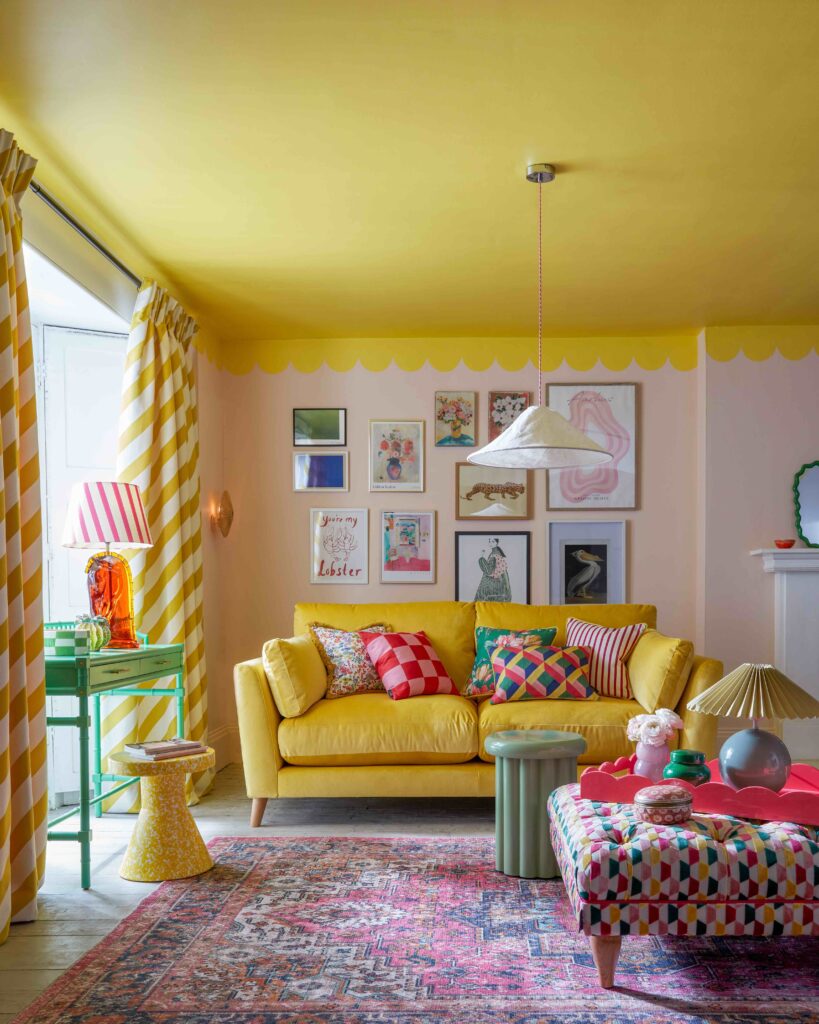 A mid century modern shaped sofa in bright yellow velvet designed by interior designer Sophie Robinson for Dfs in a sunny living dopamine decor living room